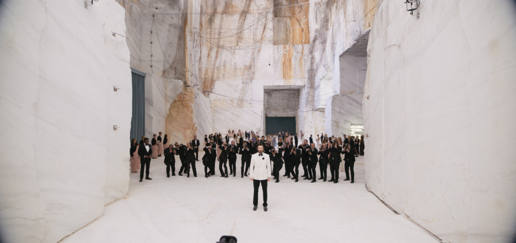 Chris Evans standing in a large white rck enclosure surrounded by people in suits in 'Sacrifice' | Agents of Fandom