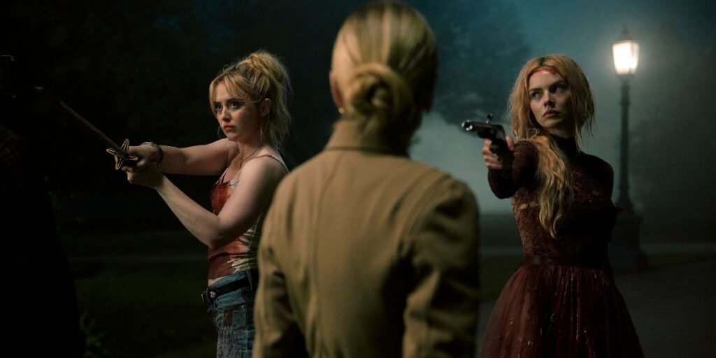 Kathryn Newton and Samarah Weaving hold up their weapons in 'Ready or Not 2: Here I Come' | Agents of Fandom