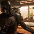 Din Djarin and Grogu in a Star Wars cantina in The Mandalorian and Grogu | Agents of Fandom
